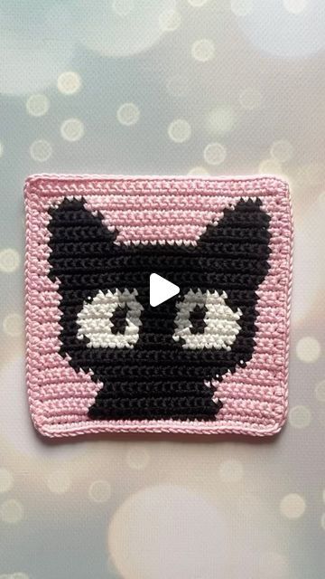 a crocheted square with a black cat on it