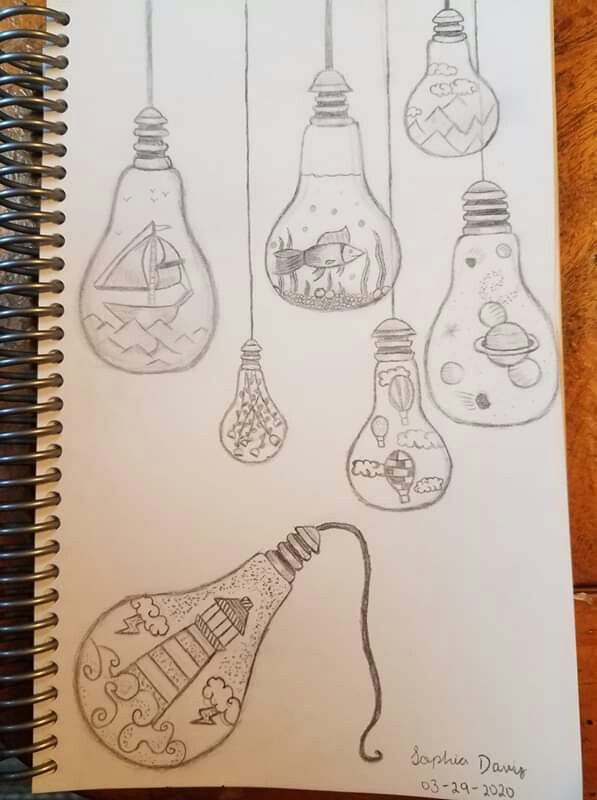 an open notebook with drawings of light bulbs hanging from it's sides and on the inside