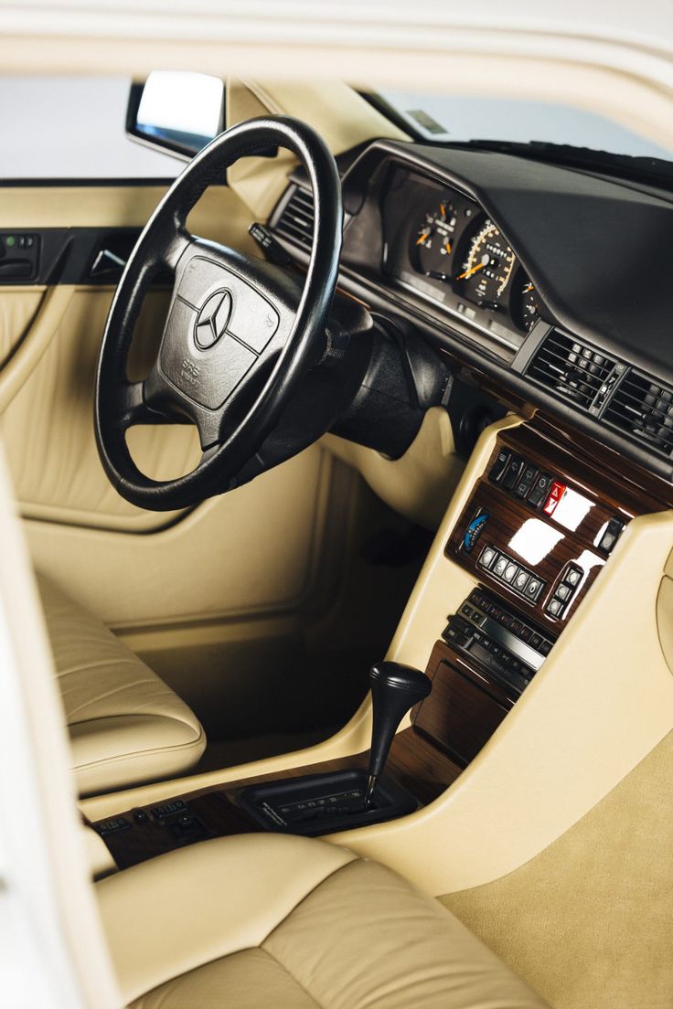 the interior of a car with beige leather and black trims, including an automatic steering wheel