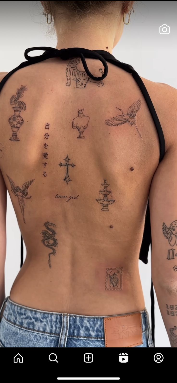 the back of a woman's body with tattoos on her upper and lower back