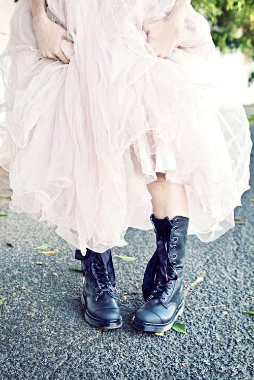 a woman wearing black boots and a white dress