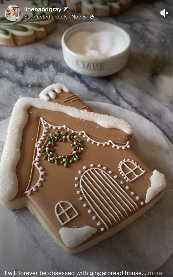 a gingerbread house decorated with icing and sprinkles on a plate