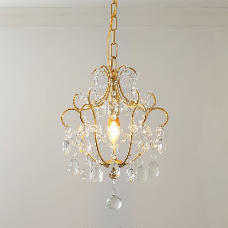 a chandelier hanging from the ceiling in a room with white walls and flooring