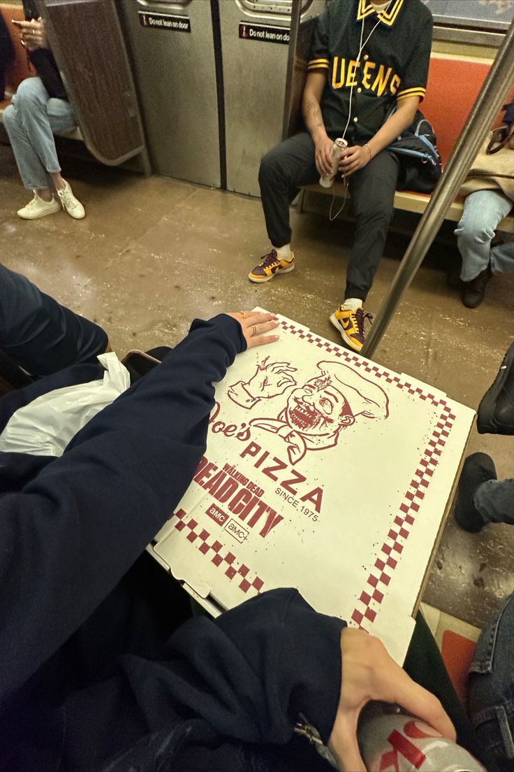 a group of people sitting on a subway train next to a sign that says pizza hut