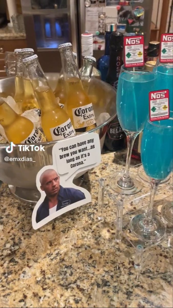 there are many bottles and glasses on the counter with some drinks in front of them