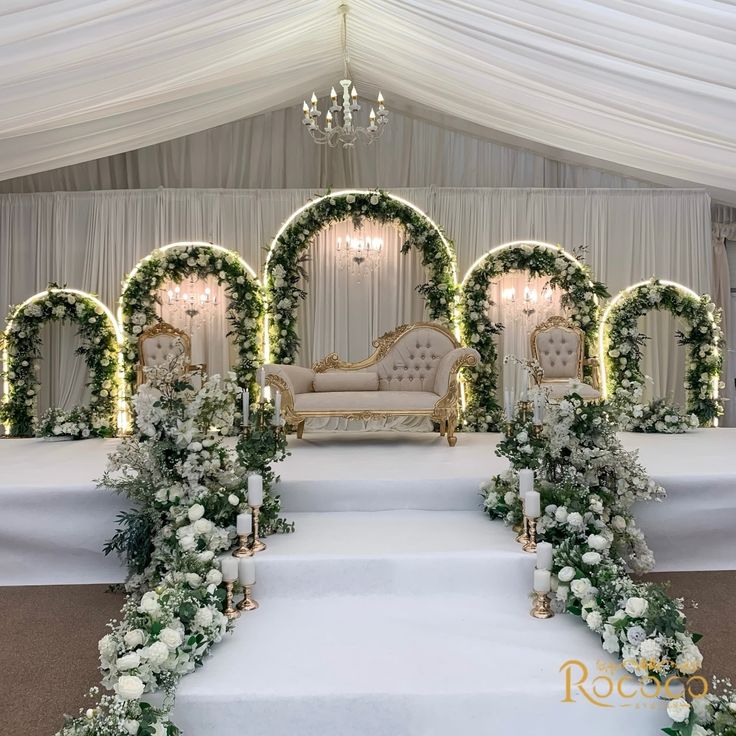 a white wedding set up with flowers and greenery