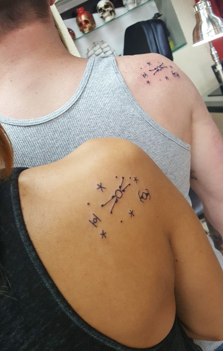 the back of a woman's shoulder with stars on it and a clock tattoo