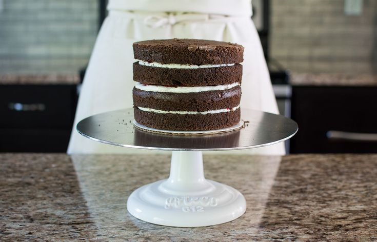 there is a cake that is on top of the counter and it has white frosting