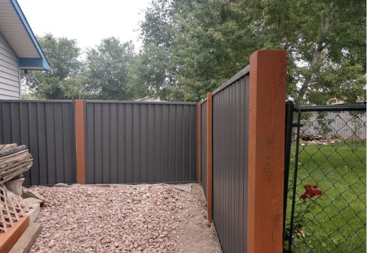 a fenced in yard with gravel and wood chips on the ground next to it