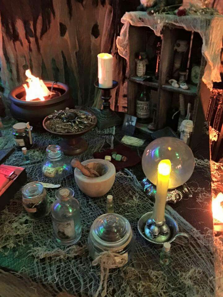 the table is covered with candles and other items for halloween decorations, such as jars