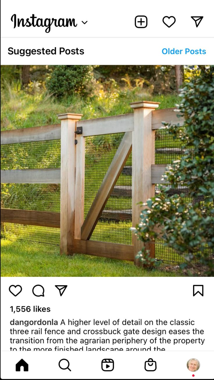 a wooden fence with a gate in the grass