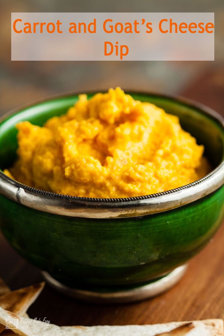 carrot and goat's cheese dip in a green bowl on top of a wooden table