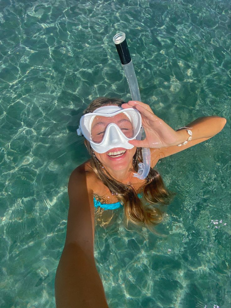 a woman in the water with a snorkel mask on