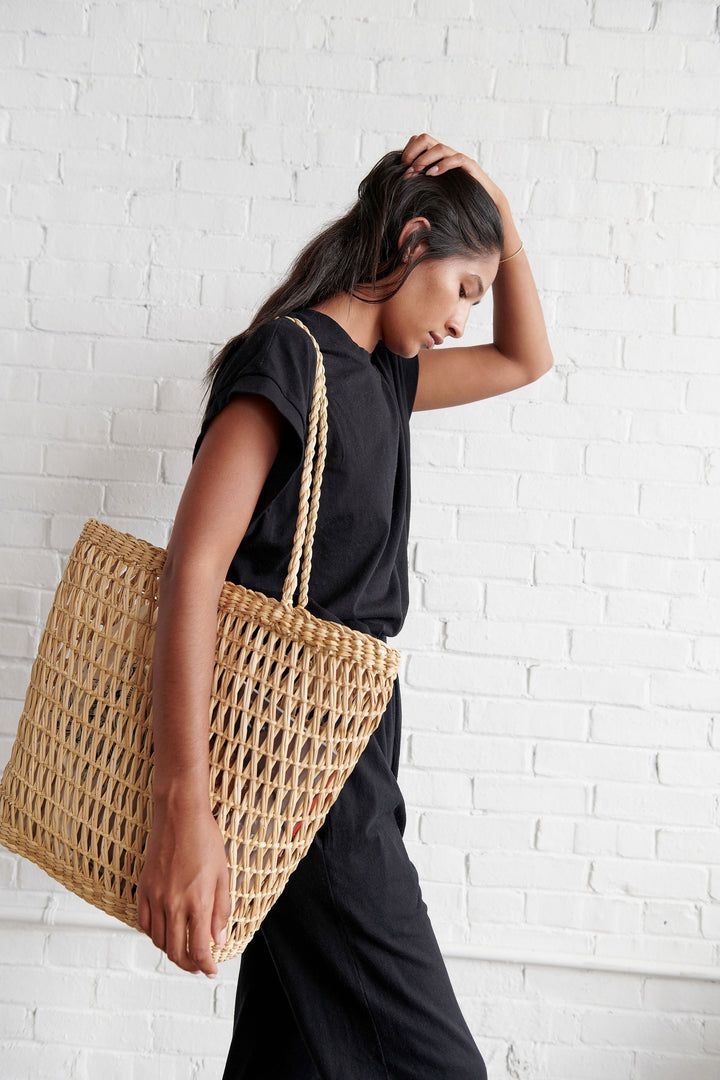 This tote is hand woven in Peru by a basket weaver with an open work technique. Big enough to be an all day carry all but is still lightweight and airy. Made with Junco Reed which is harvested from the coastal wetlands of Peru, where it grows wild and in abundance.  The reed will naturally and slightly darken with age. Everyday Woven Straw Basket Bag, Eco-friendly Beach Bag With Woven Leather, Eco-friendly Beach Bag With Woven Leather And Natural Fiber, Market Tote Straw Bag With Open Weave, Open Weave Basket Shoulder Bag For Market, Everyday Natural Fiber Beach Bag With Open Weave, Everyday Woven Leather Straw Basket Bag, Eco-friendly Woven Leather Beach Bag, Casual Natural Color Bags With Weaving