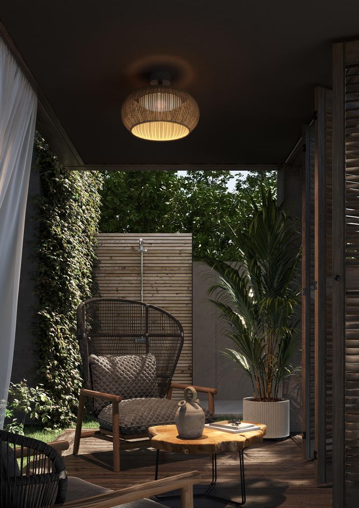 an outdoor area with chairs, table and potted plant