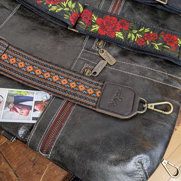 Our leather trimmed guitar-style handbag straps will instantly add personality to your favorite bag. Made with a variety of fun-colored woven prints and completely backed with high quality leather, this long adjustable 2 inch wide strap will transform the look of your Brynn Capella handbag, as long as it has d-rings to attach to. The durable leather based wide strap makes any bag super comfortable and stylish. Get more compliments than you ever imagined. Brown/Orange/Blue woven ribbon graphic di Leather Bag Strap For Travel, Trendy Leather Bag Strap For Travel, Trendy Bags With Leather Strap, Trendy Long Leather Bag Strap, Bohemian Adjustable Shoulder Strap For Travel, Leather Bag Strap With Handles For Travel, Leather Travel Bag Strap With Leather Handles, Adjustable Leather Bag Strap For Daily Use, Bohemian Long Bag Strap For Travel