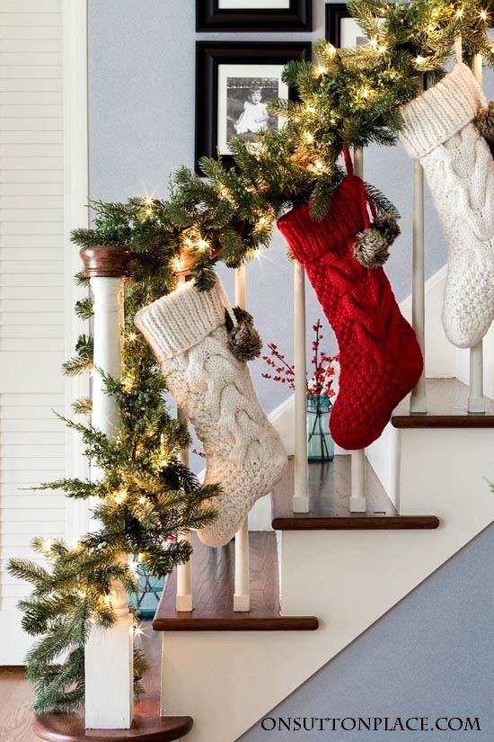 stockings hung on the banister with christmas decorations