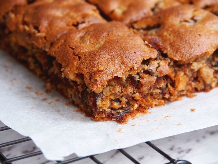 a piece of cake sitting on top of a white paper next to a cooling rack