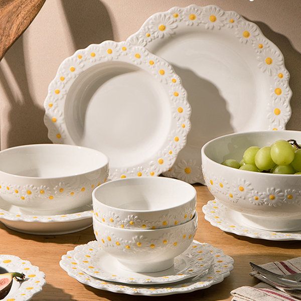 a table topped with plates and bowls filled with grapes on top of a wooden table