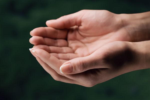 a person's hand holding something in the air with their palm extended to the side