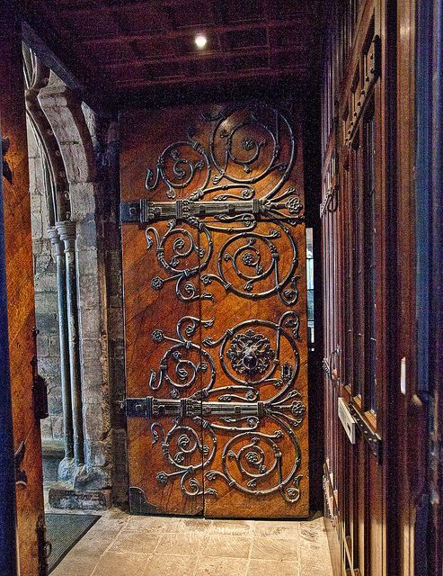 an ornate wooden door is open to the outside