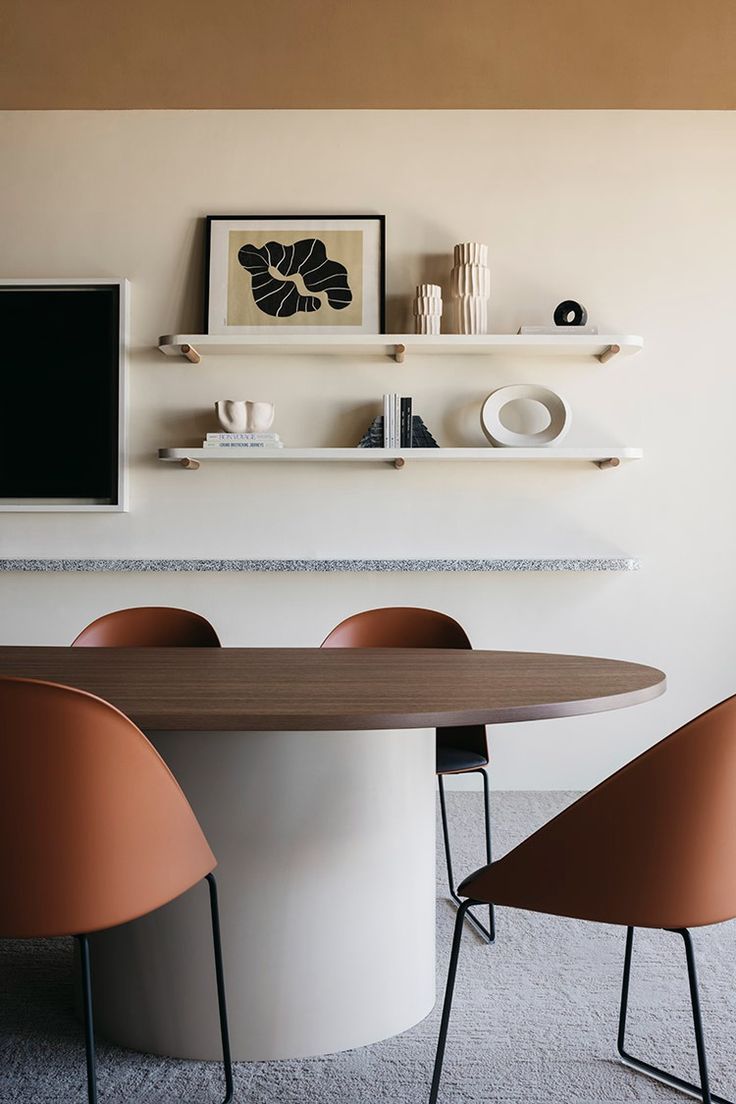 a dining table with four chairs around it in front of a wall mounted tv and shelves