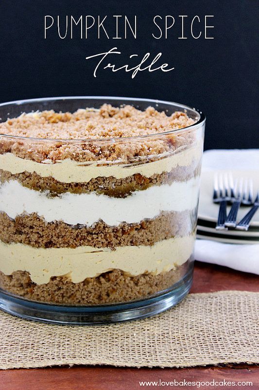 a layered pumpkin spice trifle in a glass dish on top of a wooden table