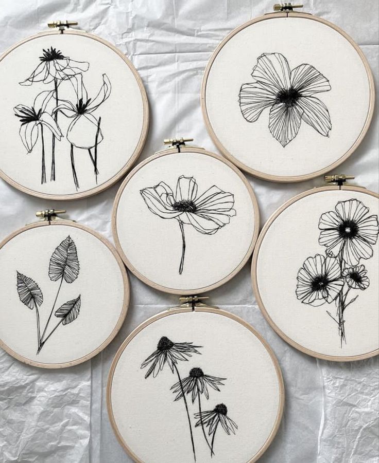 four embroidered flowers are shown in black and white