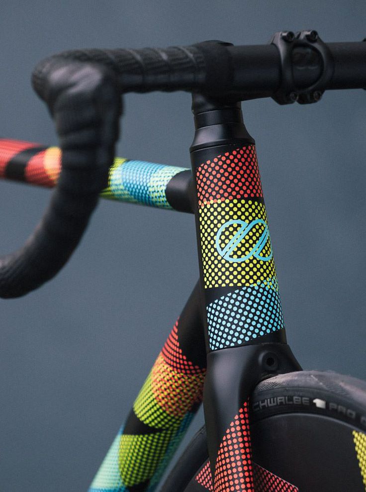 the handlebars are decorated with multicolored designs on it's bike