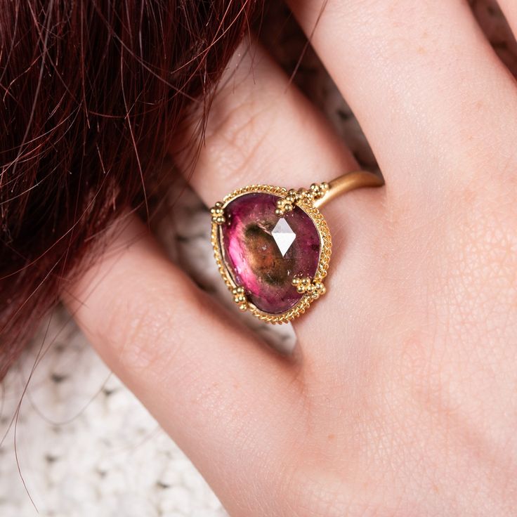 This Tourmaline looks like a portal to another world with a dark band expanding out from the center. A fun addition to your jewelry collection, this one-of-a-kind gemstone is set in a meticulously handmade gold frame accented with braided gold and granulated prongs. Ready to ship in size 7. Please allow 1-2 weeks for any other size. Technical Details Metal: 18k yellow goldTourmaline 7.53 ctsRing face: 17 x 26mmBand width: 2mmHandmade in New YorkStyle # R-2651-TOUR Portal To Another World, Watermelon Tourmaline Ring, Mixed Metal Bracelets, Textile Necklace, Raspberry Pink, Tourmaline Ring, Watermelon Tourmaline, Handmade Gold, Bracelet Collection