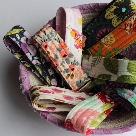 a bowl filled with lots of different colored fabric ties on top of each other,