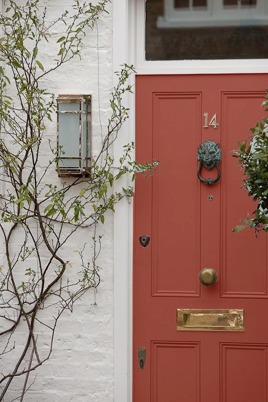 a red front door with two planters next to it