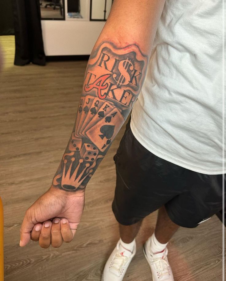 a man with a tattoo on his arm holding the hand of another person's wrist