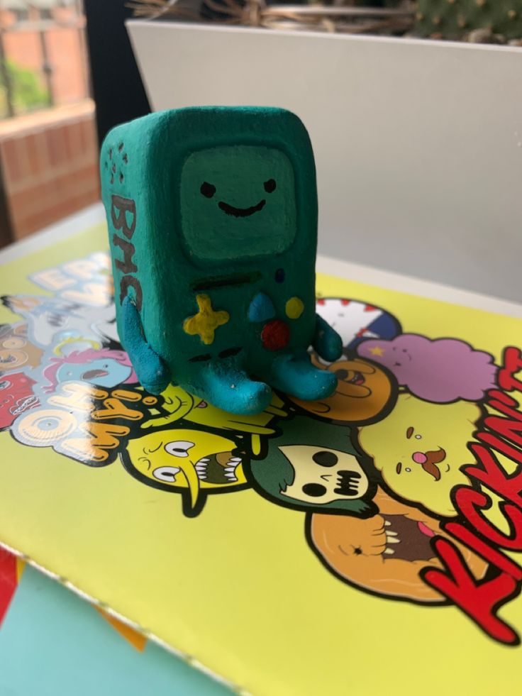 a green toy sitting on top of a table