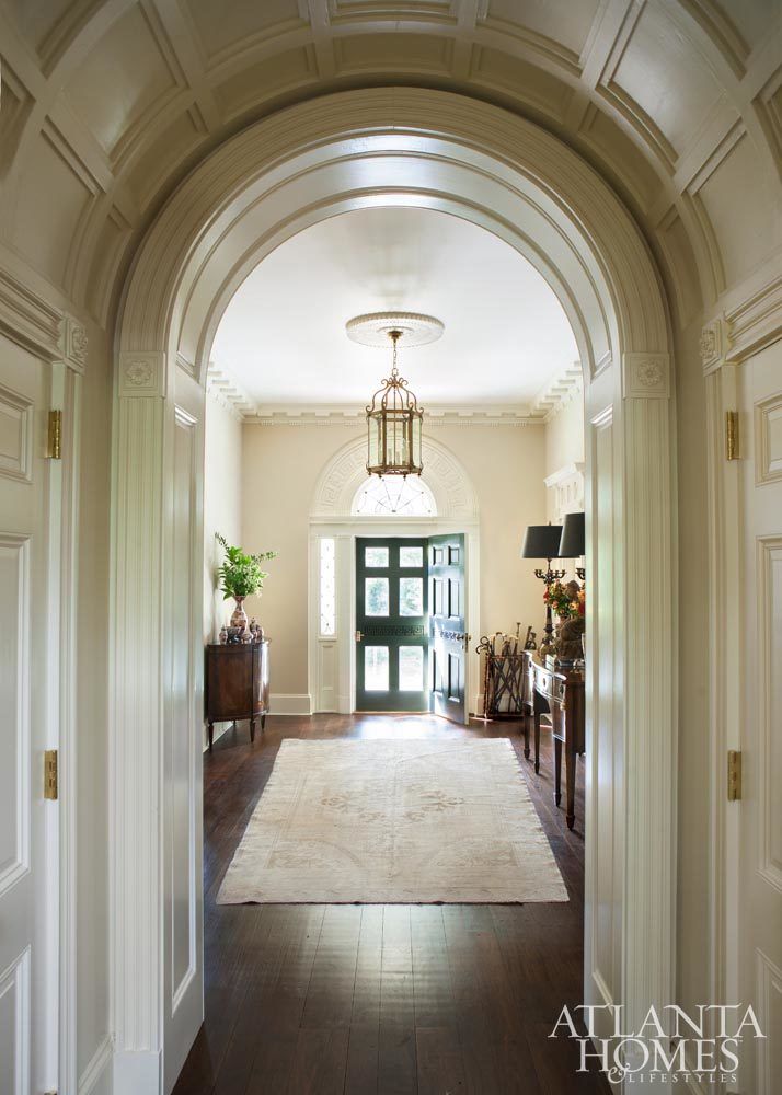 an archway leading to a living room and dining room with wood flooring on either side