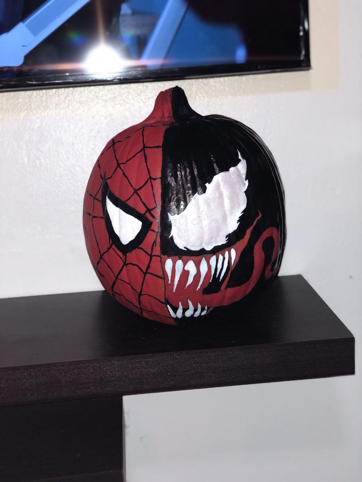 a spiderman pumpkin painted to look like it has teeth