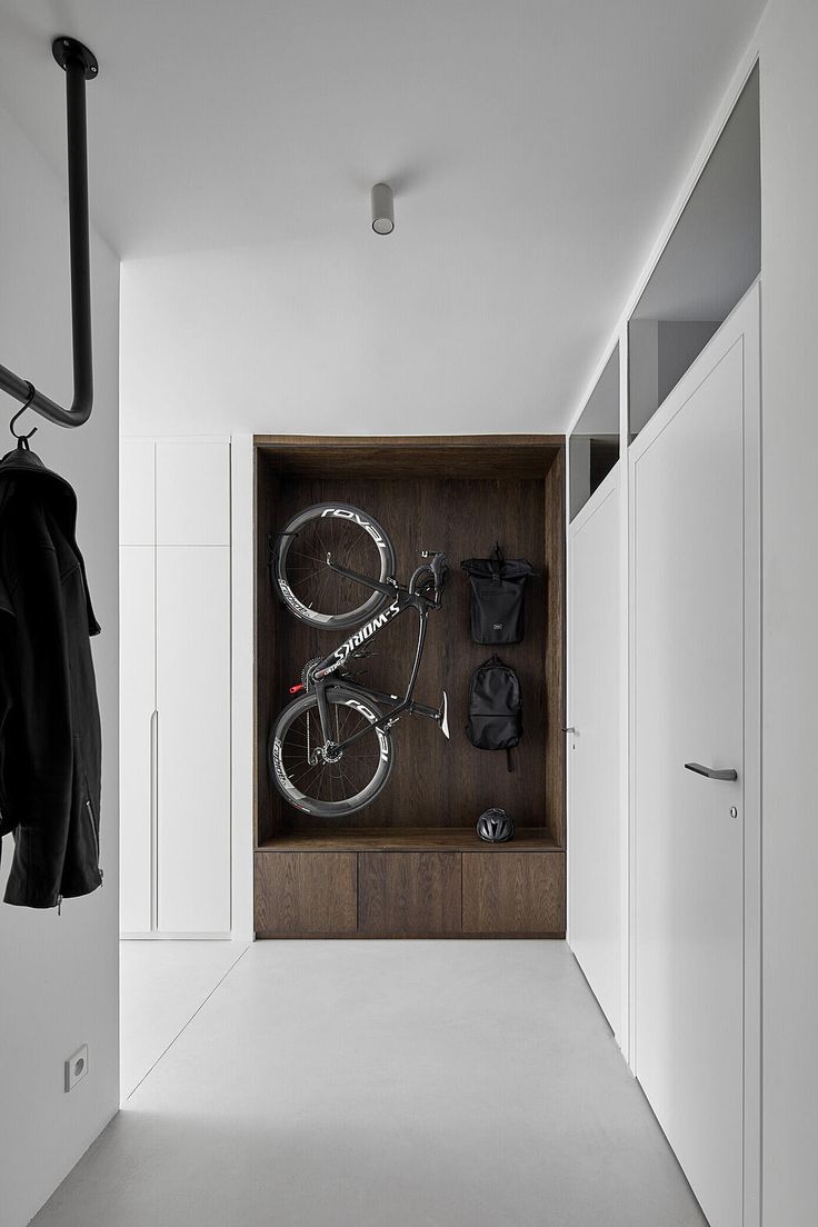 a bike is mounted to the wall in this hallway with white walls and flooring