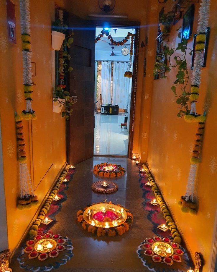 an entry way decorated with candles and decorative plates for diwaling on the floor