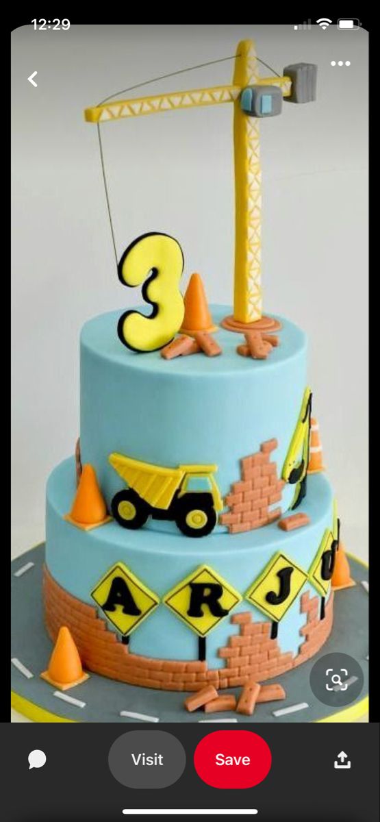 a three tiered blue cake with construction vehicles on top and the number 3 in yellow