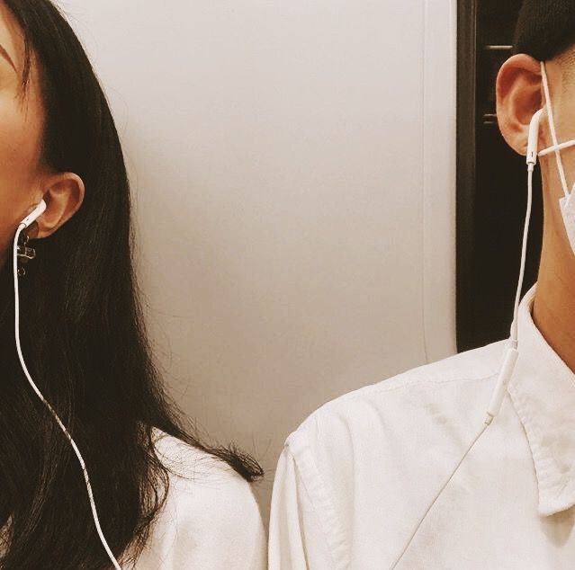 two people wearing ear buds and masks on their ears