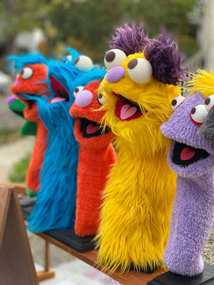 several colorful stuffed animals are lined up on a table