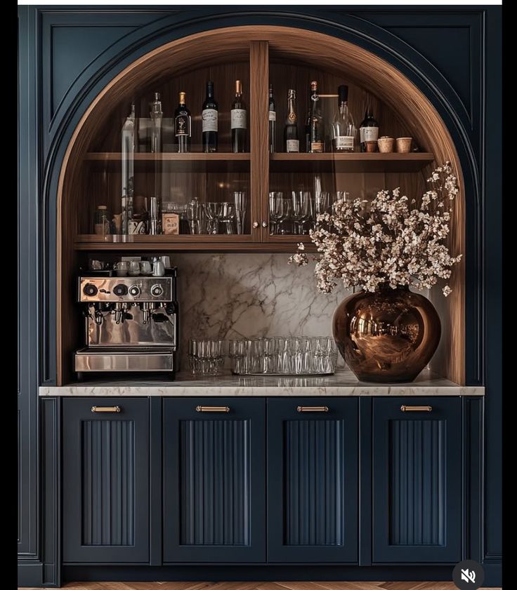 an elegant bar with blue cabinets and marble counter tops