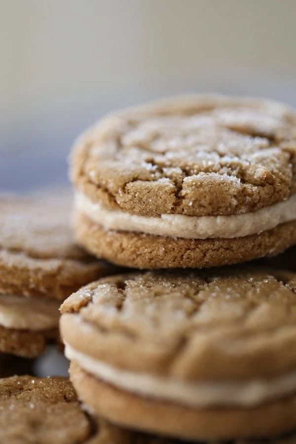 a pile of cookies with frosting on top of each one sitting on a table