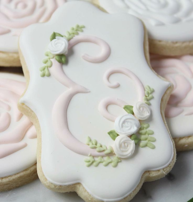 some decorated cookies on top of each other in the shape of letters and numbers with flowers