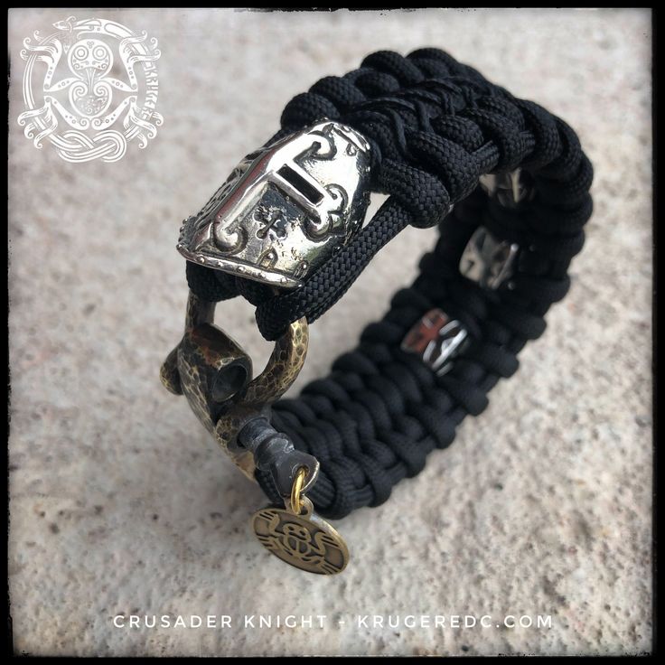 Crusader bead in white brass or copper. Three steel cube crusader beads and handmade kruger original brass adjustable shackle. Cord colors are black on black. Other colors on request. Black Spiritual Jewelry With Antique Finish, Custom Black Jewelry With Hardware For Gift, Black Jewelry With Custom Hardware As Gift, Unique Black Jewelry For Everyday Use, Black Viking Metal Jewelry, Black Viking Style Jewelry For Outdoor, Black Viking Jewelry For Outdoor, Handmade Viking Style Black Bracelet, Black Viking Style Outdoor Jewelry