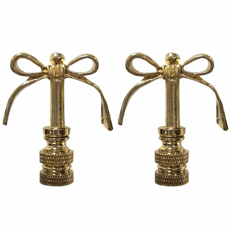 two brass candlesticks with bows on them