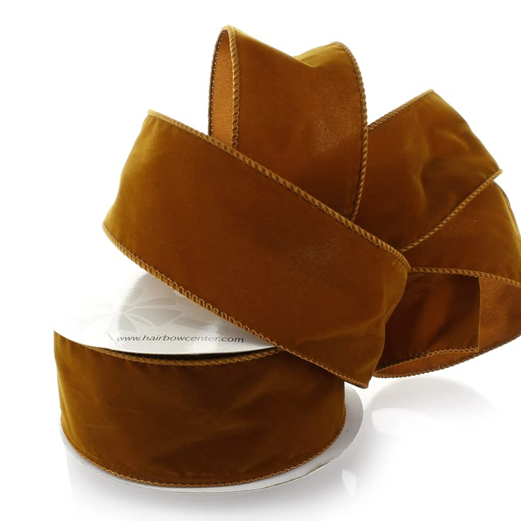 a roll of brown velvet ribbon on a white background