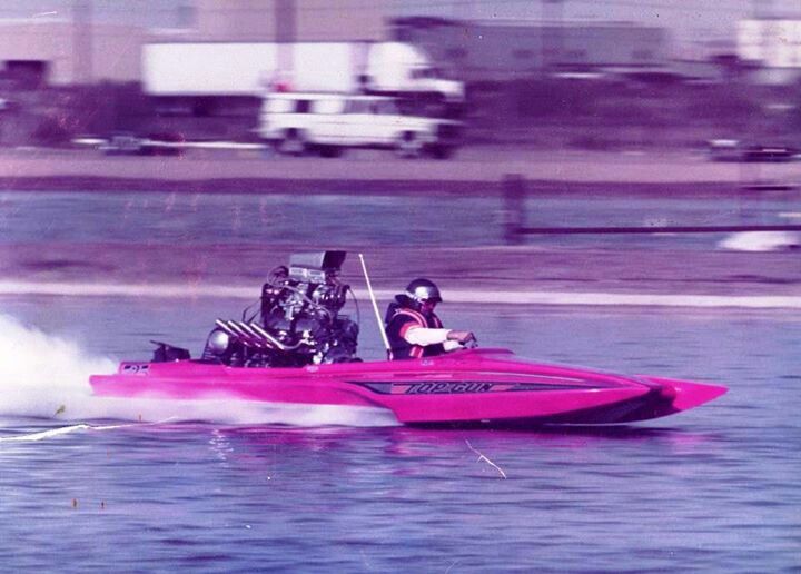 two people in a pink speed boat on the water