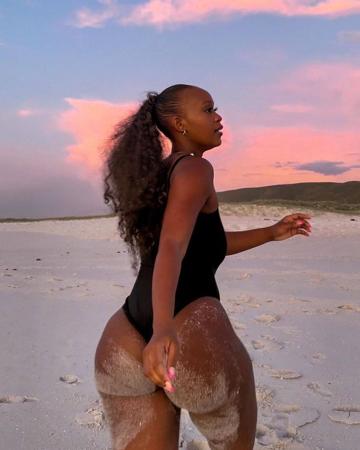 a woman standing on top of a sandy beach