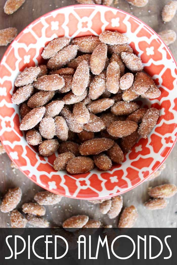 spiced almonds in an orange and white bowl with text overlay that reads spiced almonds